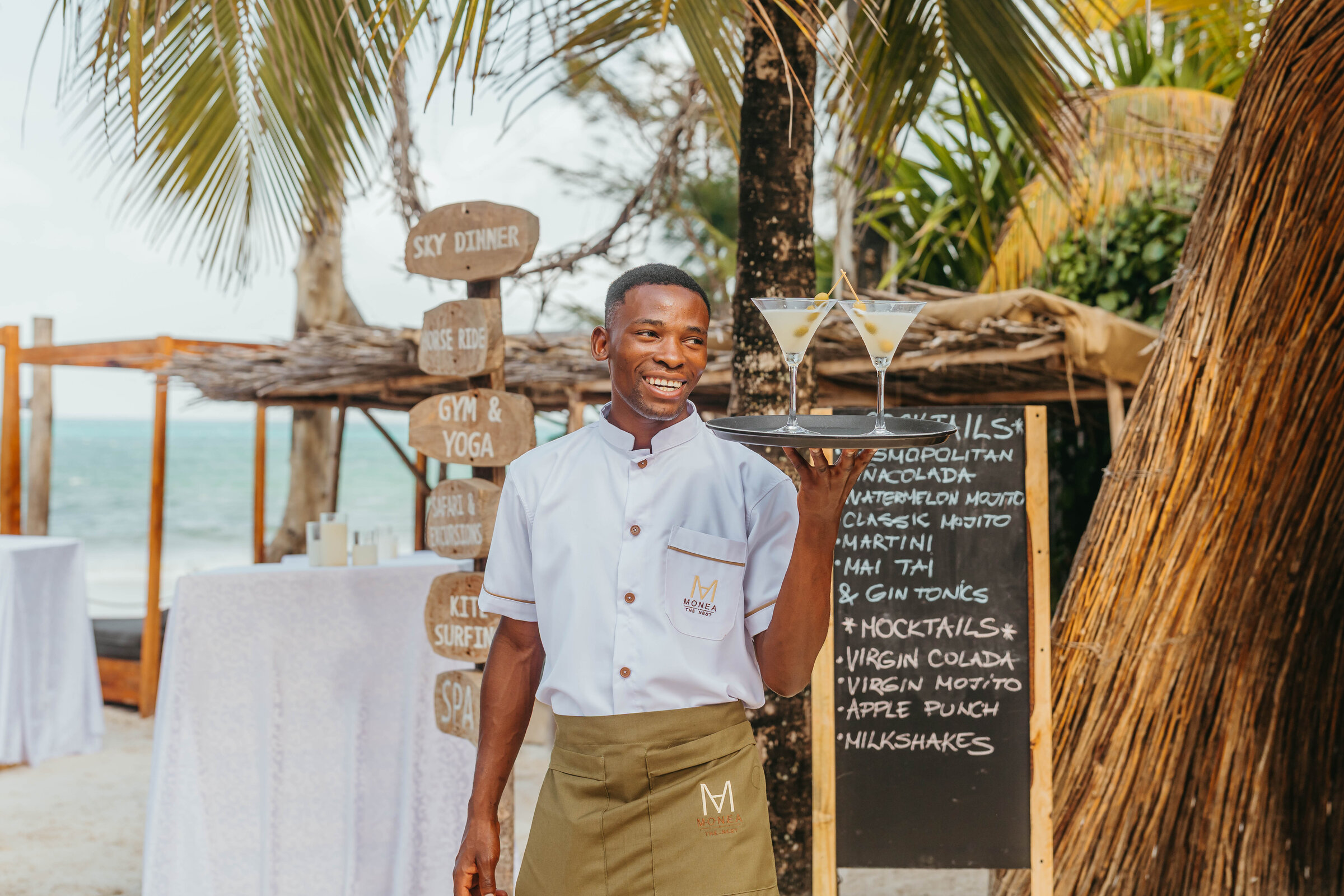 Tailored white dinner jacket hanging from a driftwood display at a beach venue