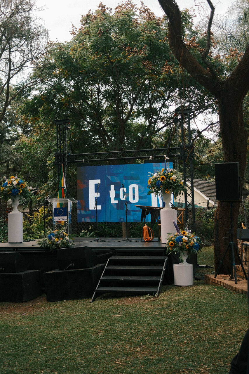 Speakers at a branded podium with blue and yellow floral styling