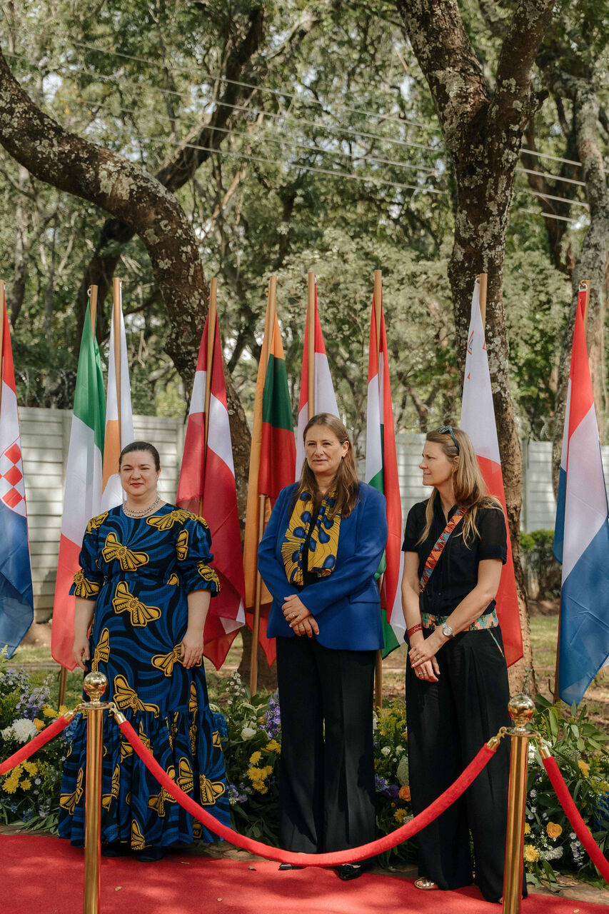 Guests photographed against a backdrop of national flags
