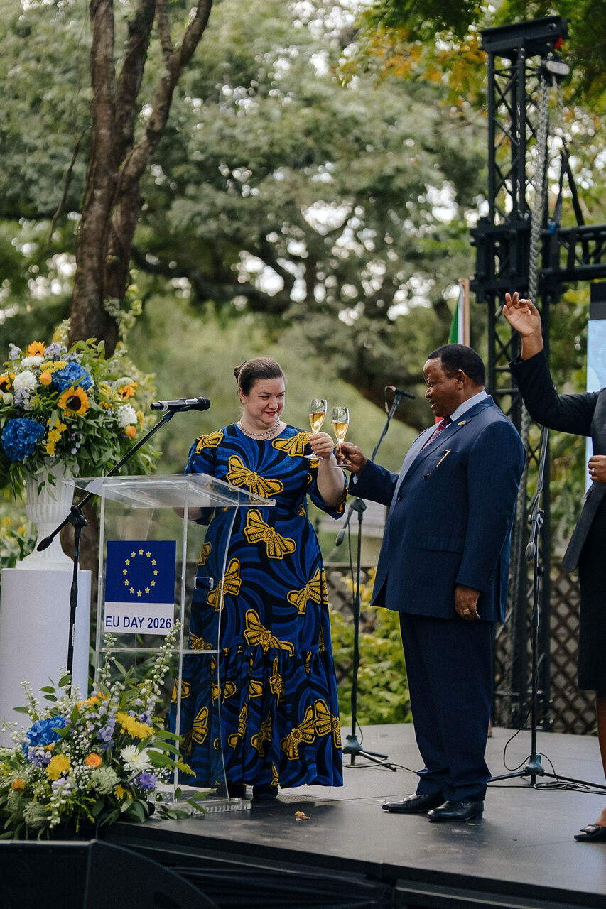 Speakers addressing guests from a floral-framed podium