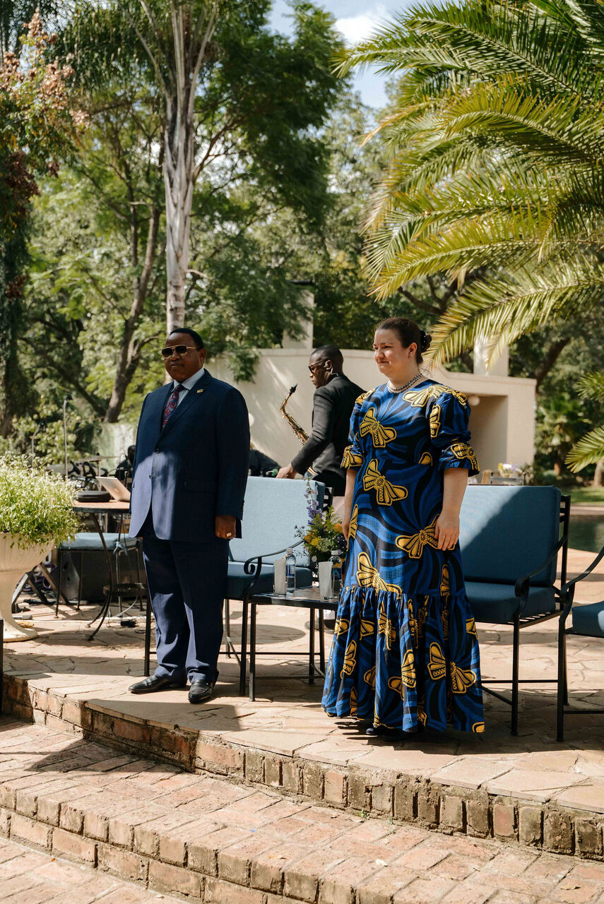 Seated hosts on a raised terrace at a garden reception