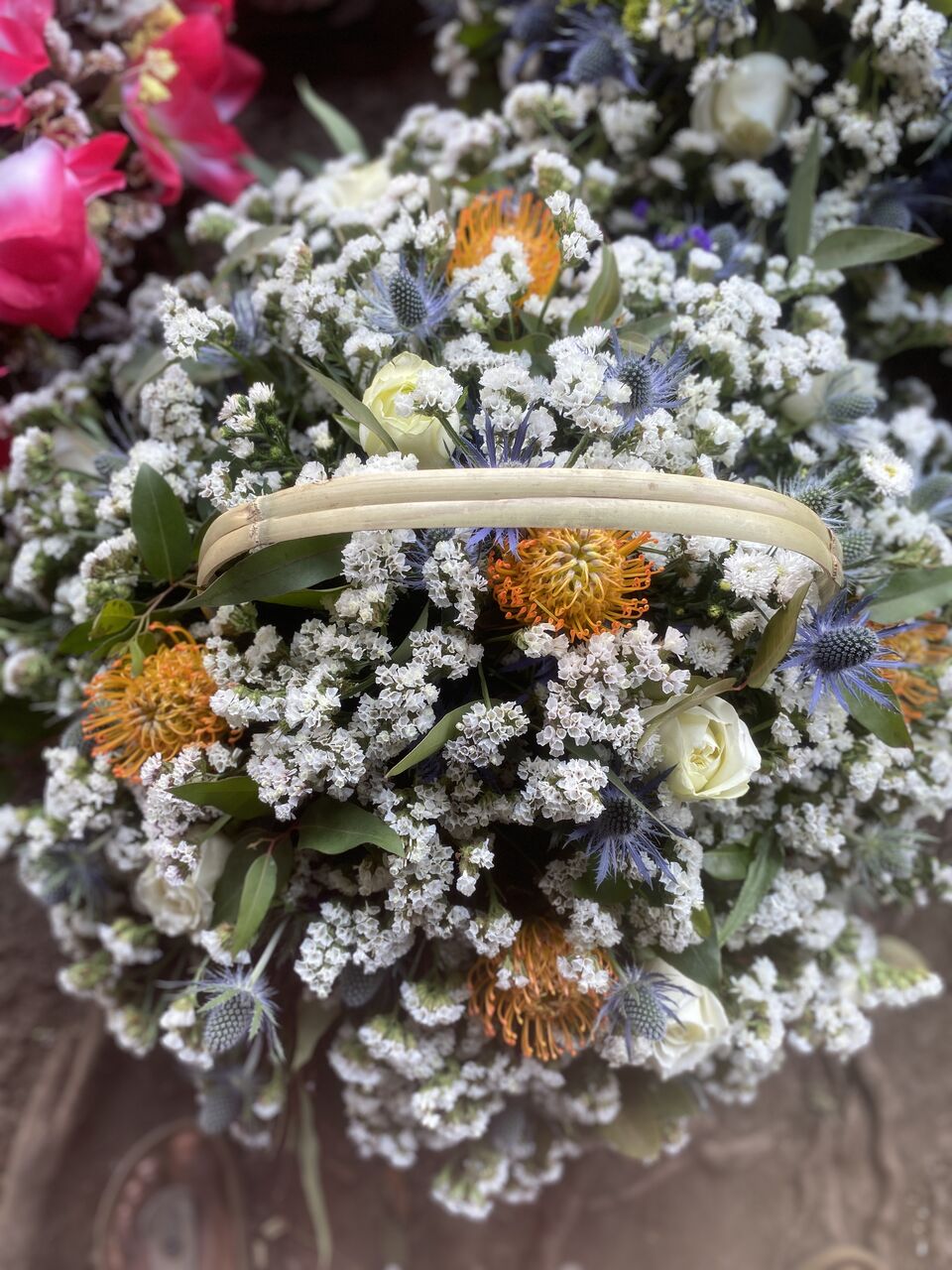 Hand-tied arrangement of white blooms, thistle and seasonal foliage