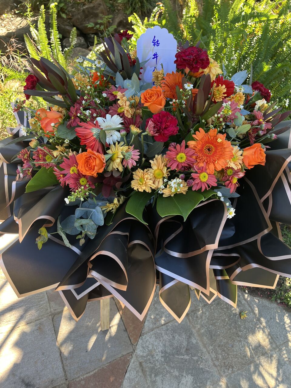 Mixed seasonal arrangement in warm tones with structured wrapping
