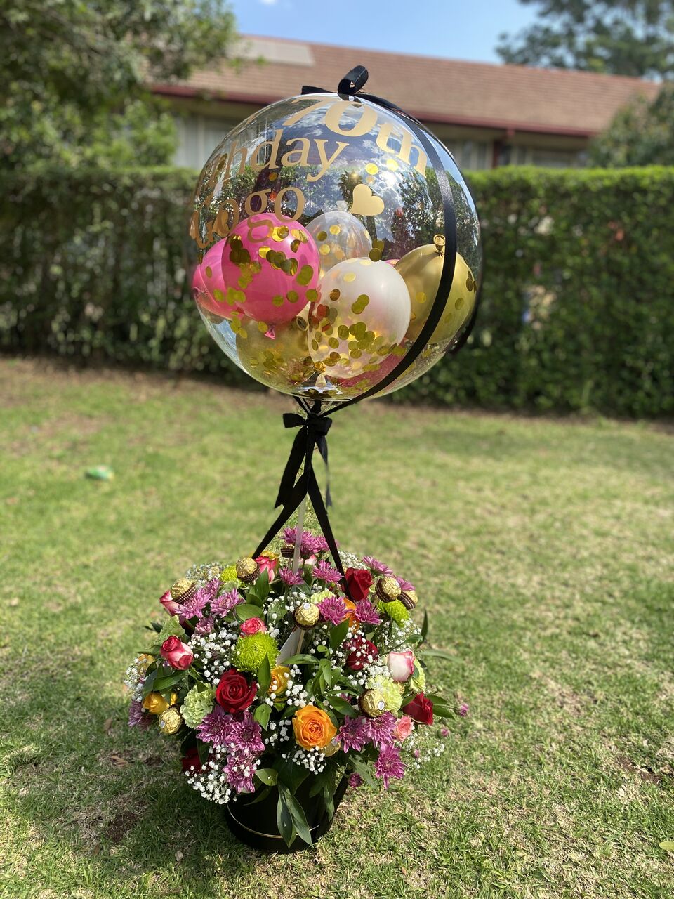 Celebration arrangement paired with a decorated balloon feature