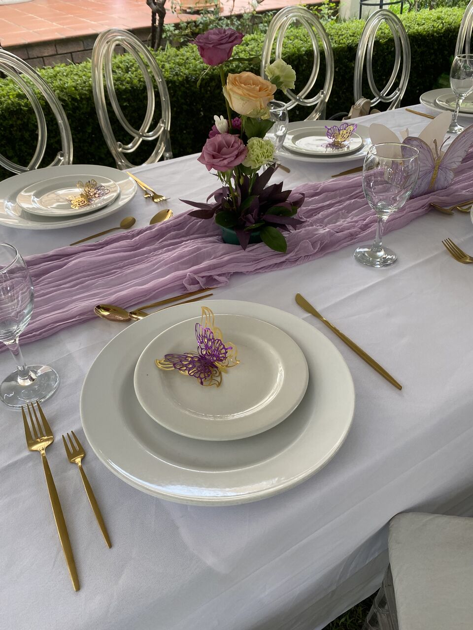 Place setting in mauve and ivory with gold cutlery and dried floral detail