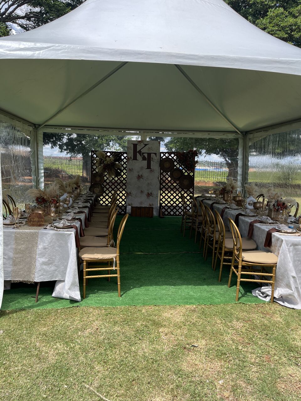 Marquee reception set with long tables and timber chairs